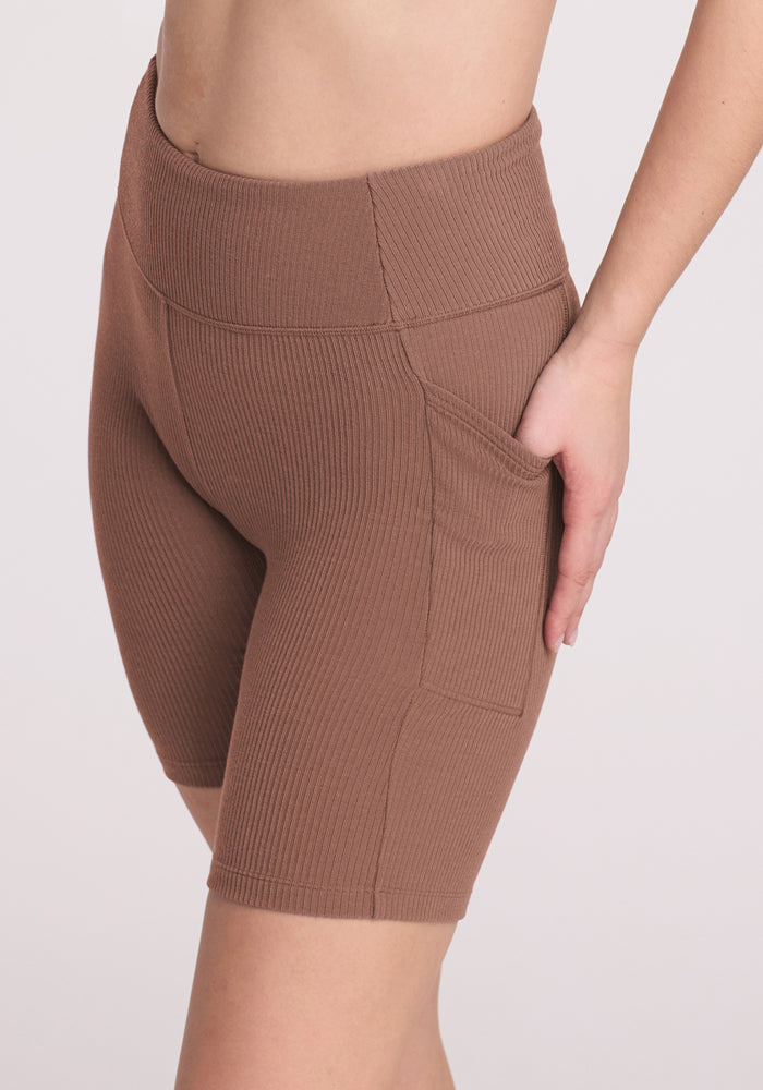 Model wearing Woolx Miley Bike Shorts in Sienna Kiss, featuring a side pocket and moisture-wicking fabric.