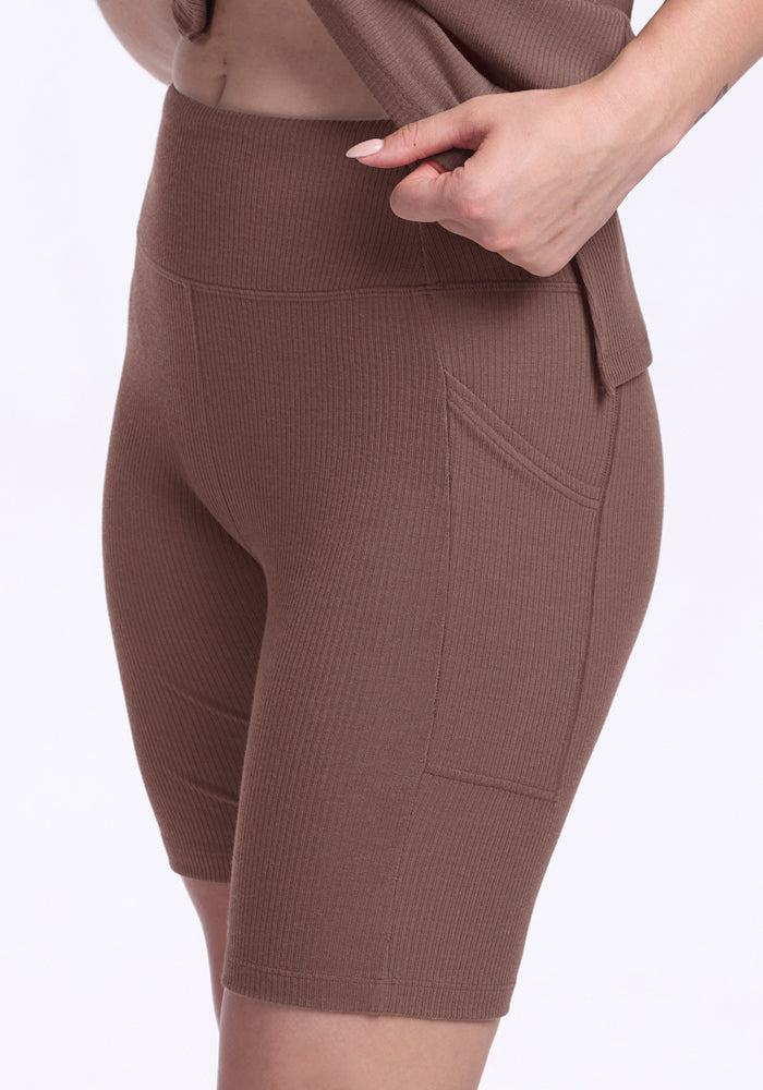 Person wears Woolx Miley Bike Shorts - Peppercorn: high-waisted, ribbed, breathable shorts with side pockets.