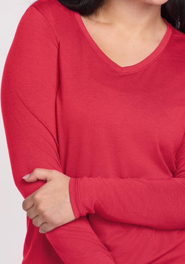 Woman wearing the Woolx Millie Long Sleeve in Berry Ice Pop crosses her arms, torso and part of face shown.