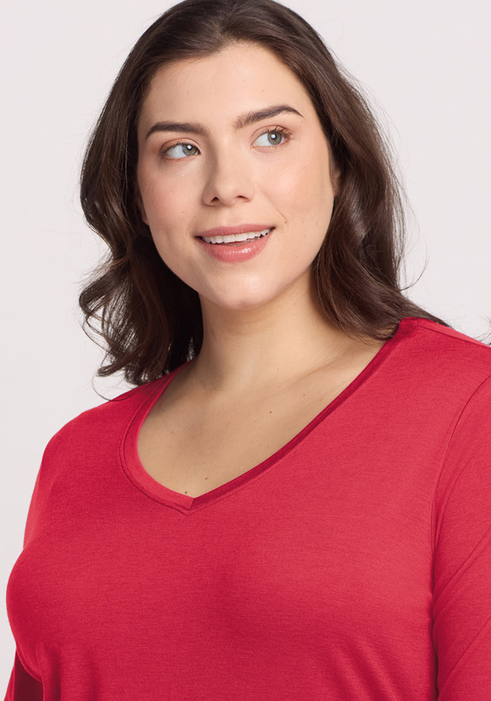 Woman with wavy brown hair wears the Woolx Millie Long Sleeve in Berry Ice Pop, smiling and looking to the side.
