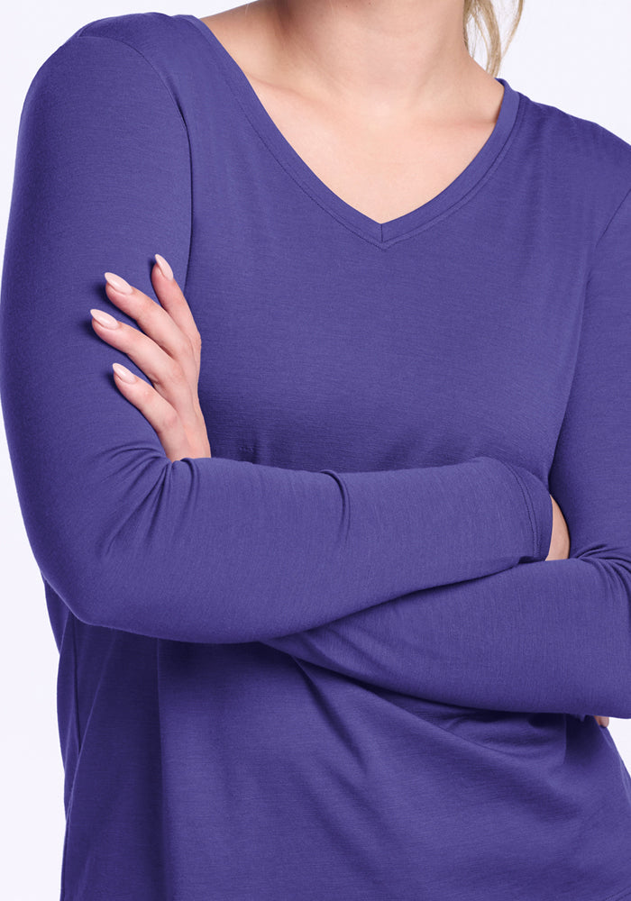 A person wears the Woolx Millie Long Sleeve in Berry Indigo, arms crossed, showing only their torso and lower face.