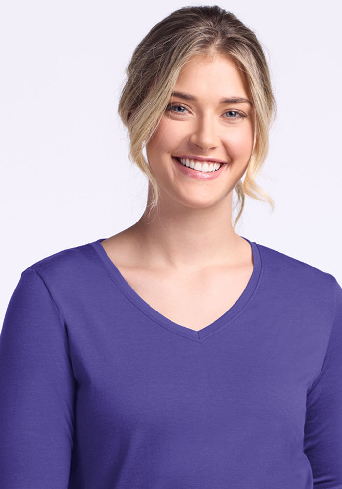 Blonde woman smiling in the Woolx Millie Long Sleeve - Berry Indigo, standing against a light background.