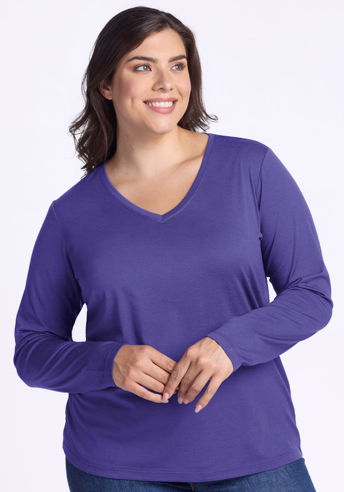 Smiling woman in Woolx Millie Long Sleeve - Berry Indigo and jeans stands against a plain light background. | Juliana is 5'10", wearing a size XL