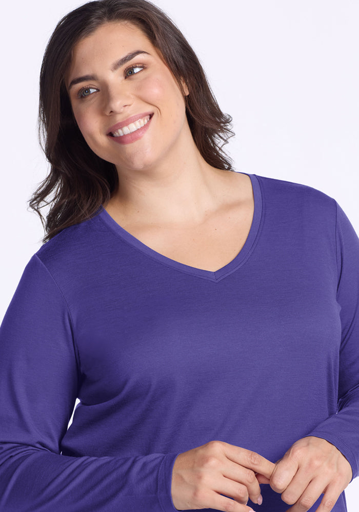 Smiling woman in Woolx Millie Long Sleeve - Berry Indigo; moisture-wicking Merino wool comfort.