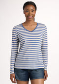 A woman stands facing forward, smiling, in the Woolx Millie Long Sleeve - Blue Sand Stripe top and denim shorts against a plain light background. | Jade is 5’10”, wearing a size S