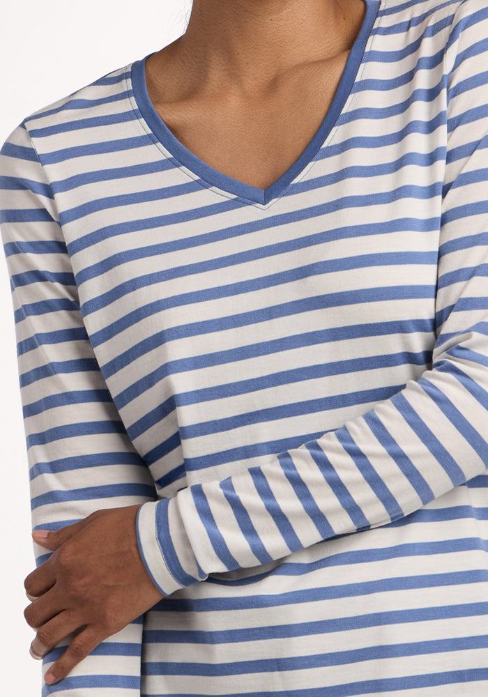A person wearing the Woolx Millie Long Sleeve in Blue Sand Stripe, arms crossed, shown from shoulders to waist.