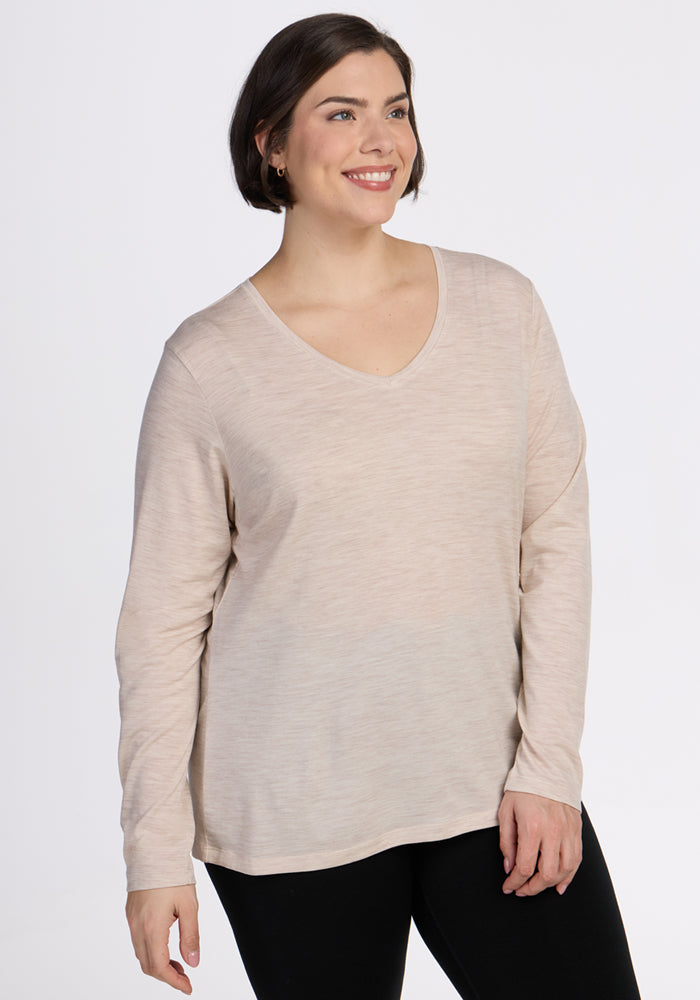 A woman with short brown hair wears the Woolx Millie Long Sleeve in Cream Heather and black pants, smiling against a plain white background. | Juliana is 5'10", wearing a size XL
