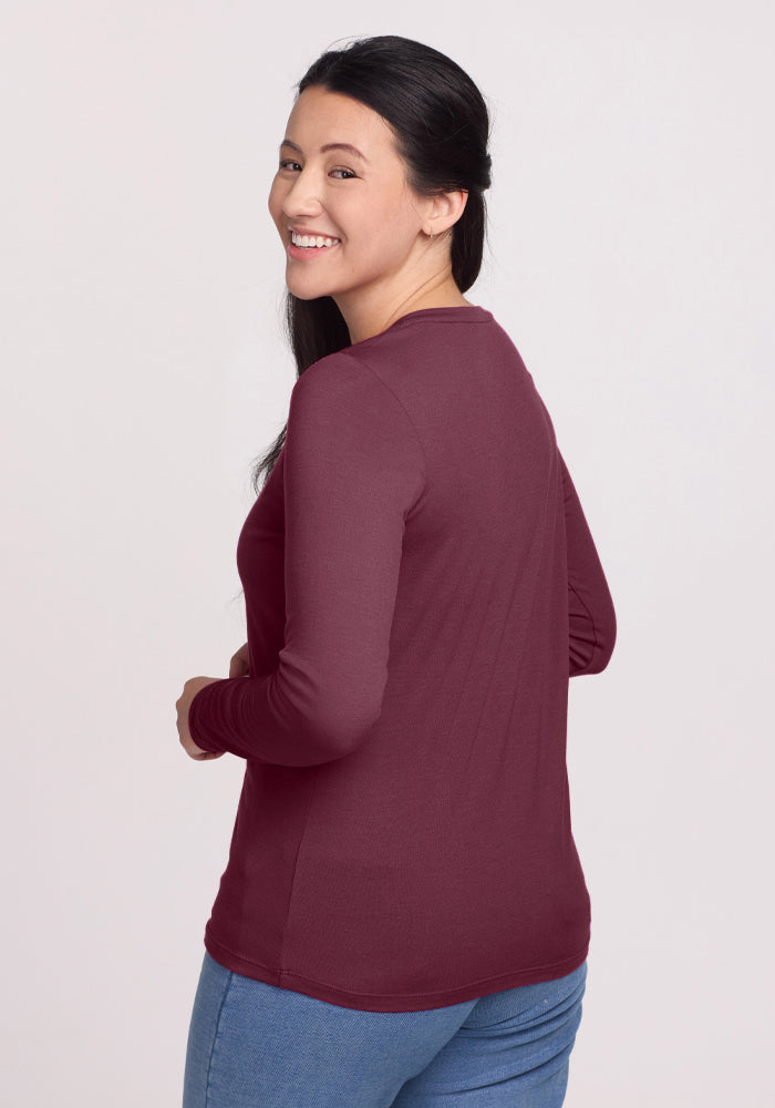 Woman in Woolx's Millie Long Sleeve in Grape Harvest, smiling over her shoulder in comfy, stylish Merino wool.