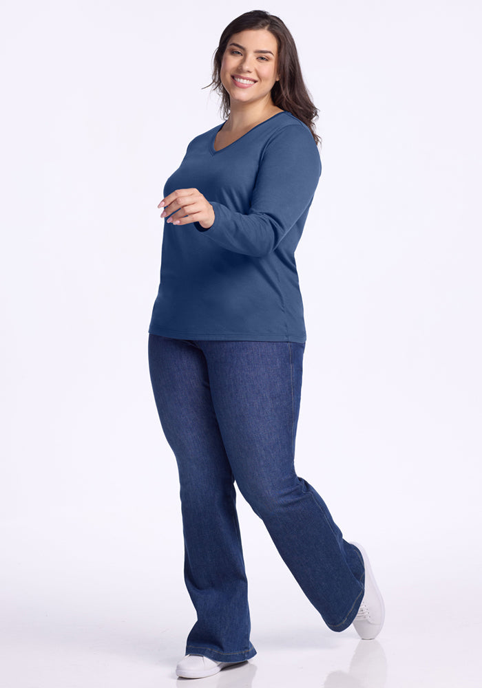 Smiling woman in Woolx Millie Long Sleeve • Final Sale - Starry Night and jeans poses with one foot raised.