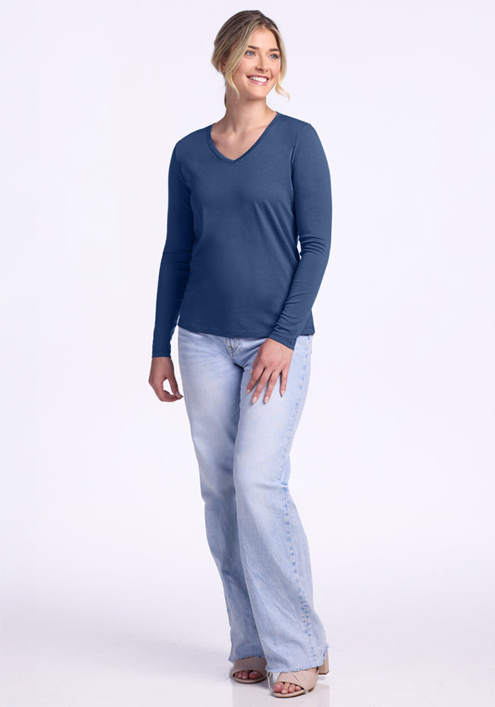 Smiling woman in Woolx Millie Long Sleeve • Final Sale - Starry Night, with light blue jeans, against white background.