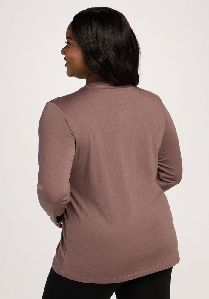 Woman smiles facing away in the Woolx Millie Long Sleeve - Peppercorn and black pants against a plain background.