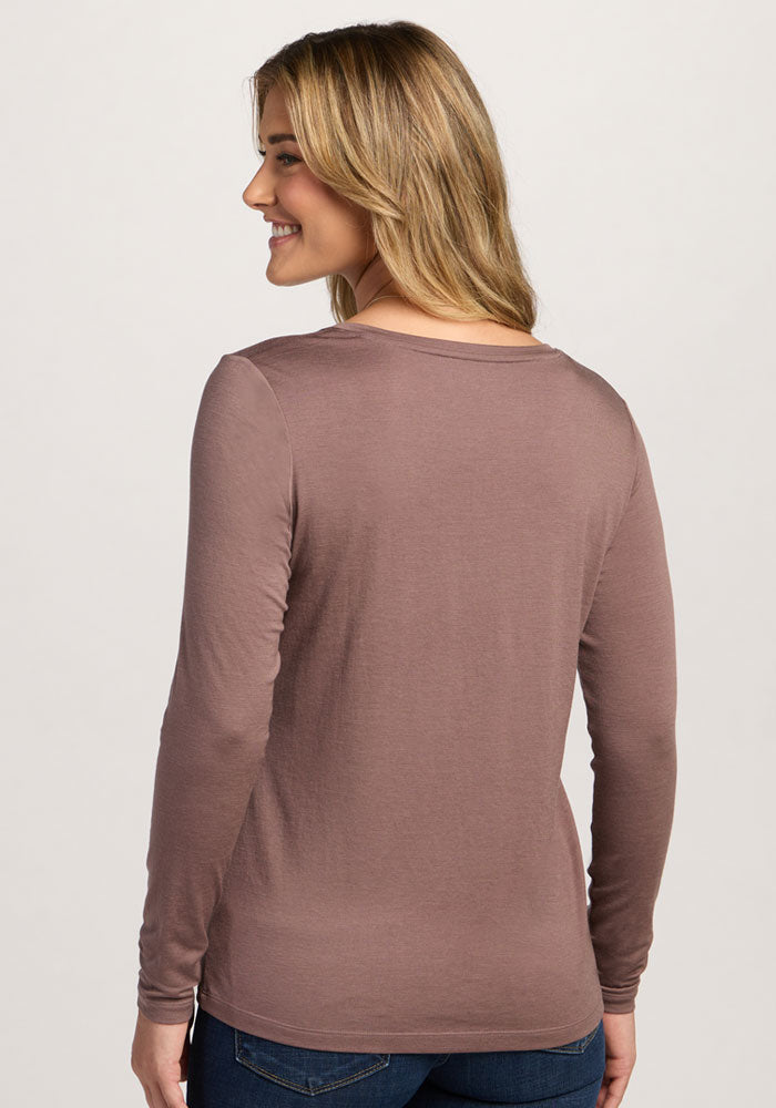 A woman with long hair smiles, shown from the back in Woolx's Millie Long Sleeve in Peppercorn and jeans.