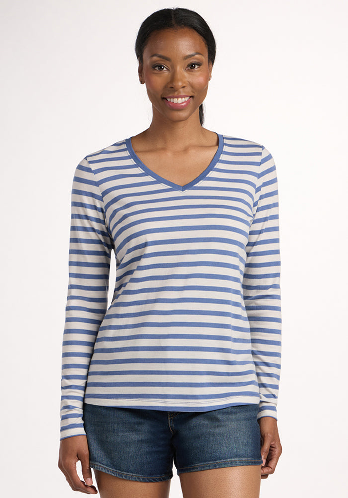 A woman stands facing forward, smiling, in the Woolx Millie Long Sleeve - Blue Sand Stripe top and denim shorts against a plain light background. | Jade is 5’10”, wearing a size S