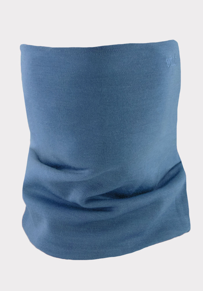 The Woolx Neck Gaiter • Final Sale - Steel Blue is shown upright on a neutral backdrop, showcasing its smooth texture and cylindrical shape—ideal as an outdoor neck warmer crafted from premium Australian Merino wool.