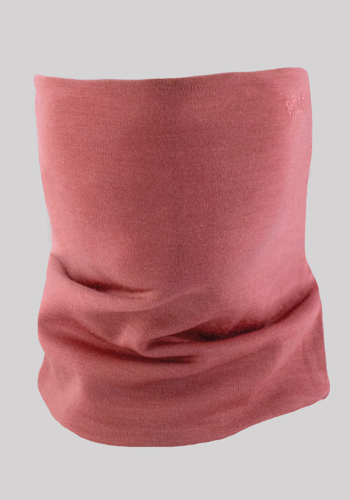 The Woolx Neck Gaiter in Brick Dust, made from luxurious Australian Merino Wool, is showcased against a simple gray backdrop. The smooth fabric is gently folded to emphasize its relaxed and cozy design, making it ideal for outdoor adventures.
