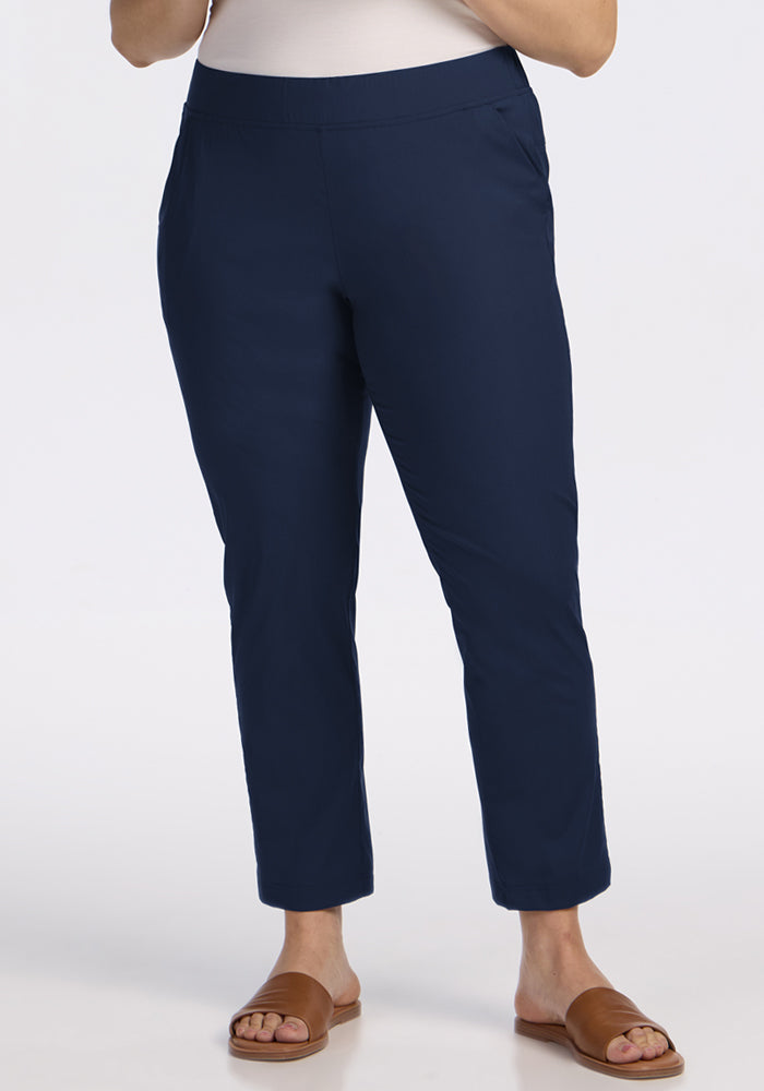 A model showcases the Woolx Nicole Ankle Pants in Deep Navy, styled with brown slide sandals, against a plain white background. Only the lower half of the body is shown. | Juliana is 5'10", wearing a size XL