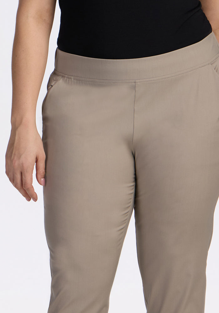 Model wears Woolx Nicole Ankle Pants in Vintage Khaki, featuring a smooth, fitted waistband and side pockets. Shown from mid-torso to mid-thigh with a relaxed arm, paired with a black top. Pants are lightweight and breathable.