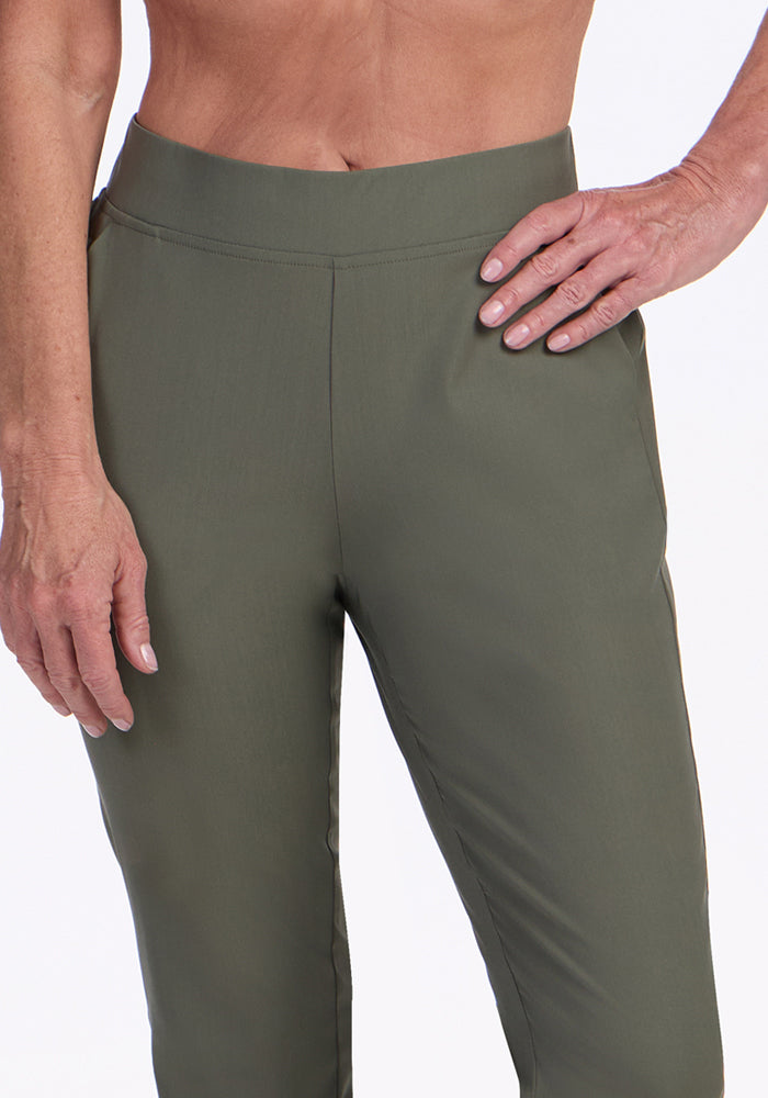 A model wears the Woolx Nicole Petite Ankle Pant in Sage Olive, standing with one hand on their hip and the other by their side. The image is cropped from mid-chest to mid-thigh against a plain white background.