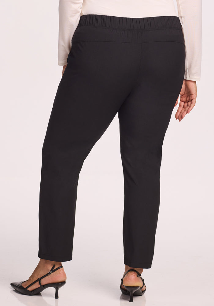 A person's back in Woolx Nicole Tall Ankle Pant - Black, featuring a lightweight, breathable fabric and tapered leg.
