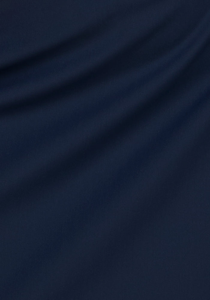 The Nicole Tall Ankle Pant in Deep Navy by Woolx features a soft, textured fabric with gentle diagonal folds, offering moisture-wicking comfort and all-day wear. Ideal for those seeking style and performance in a merino wool pant.