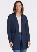 A woman with shoulder-length brown hair wears the Woolx Paisley Cardigan in Deep Navy over a white top and blue jeans, smiling against a plain white background—an essential piece for any wardrobe. | Jessica is 5’10”, wearing a size S