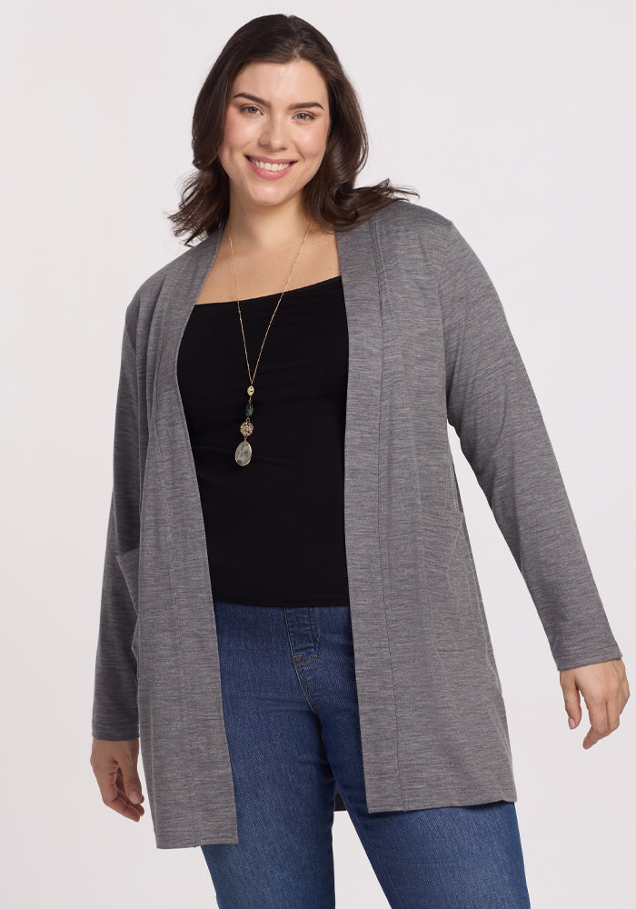 A woman smiles wearing a Woolx Paisley Cardigan in Graphite Heather over a black top and blue jeans. Her long necklace complements her wavy brown hair against the plain white background, exuding effortless style and feather-light comfort. | Juliana is 5'10", wearing a size XL