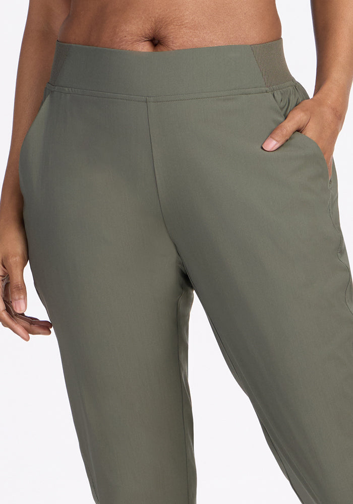 A person wearing Woolx Palmer Joggers in Sage Olive with their right hand in the pocket; image is cropped from waist to mid-thigh.