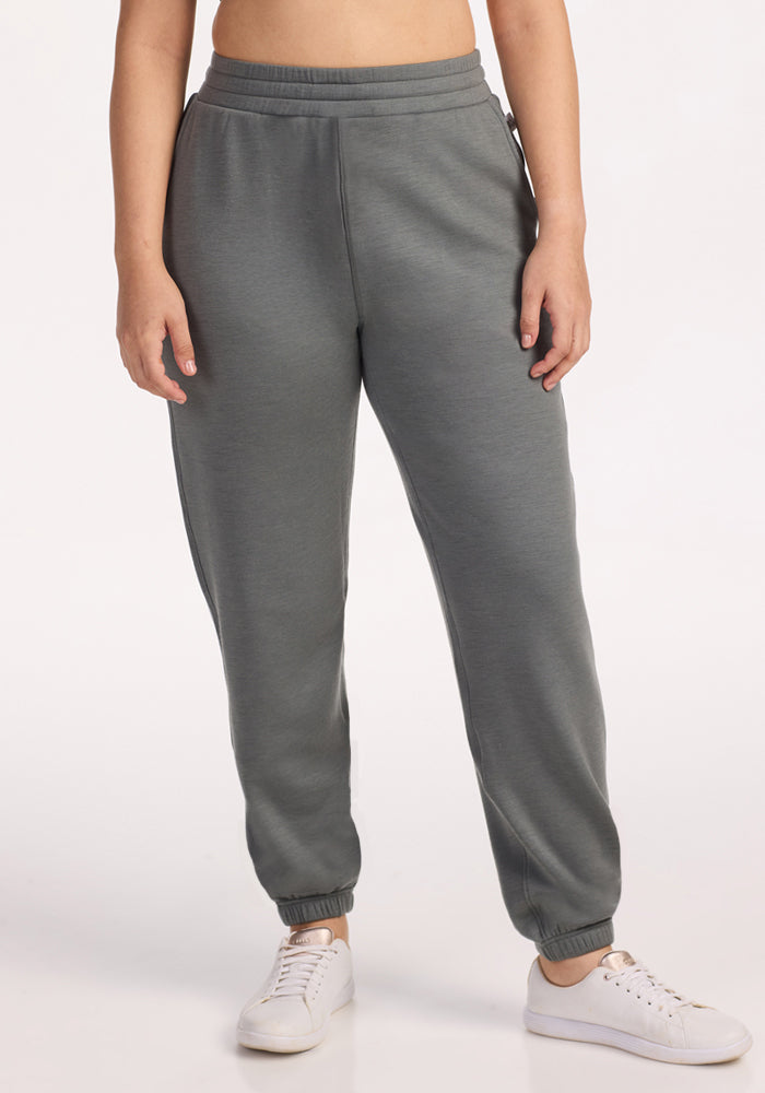 A person models the Woolx Parker Sweatpants • Final Sale - Sedona Sage, paired with white sneakers against a plain white background. Their upper body is partially out of frame and their arms are relaxed at their sides.