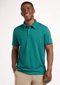 A man smiles in a Woolx Preston Polo - Woodland Mini Stripe and beige pants, standing against a plain white background. | Trell is 6’2”, wearing a size M