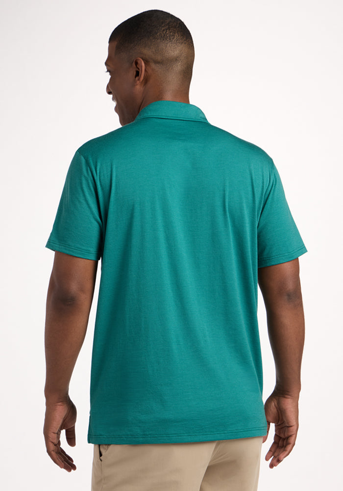 A man faces away from the camera in a teal Woolx Preston Polo - Woodland Mini Stripe, a moisture-wicking shirt, paired with beige pants. The background is plain white.