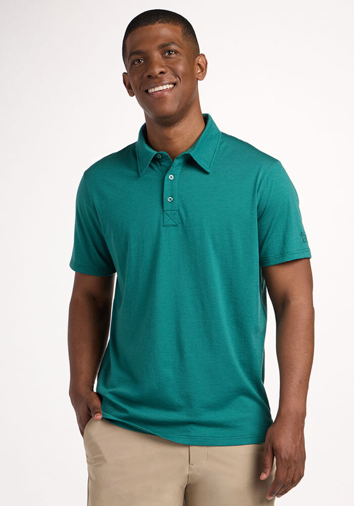 A man smiles in a Woolx Preston Polo - Woodland Mini Stripe and beige pants, standing against a plain white background. | Trell is 6’2”, wearing a size M