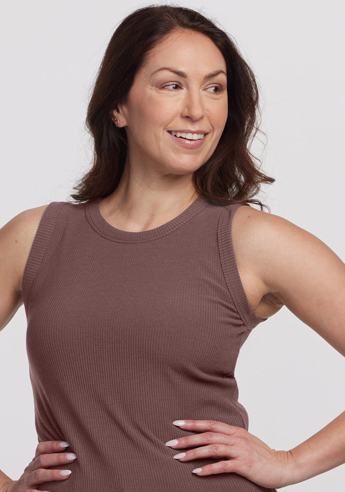 Smiling woman with long brown hair wears the Woolx Raegan Ribbed Tank Top in Peppercorn, hands on hips.