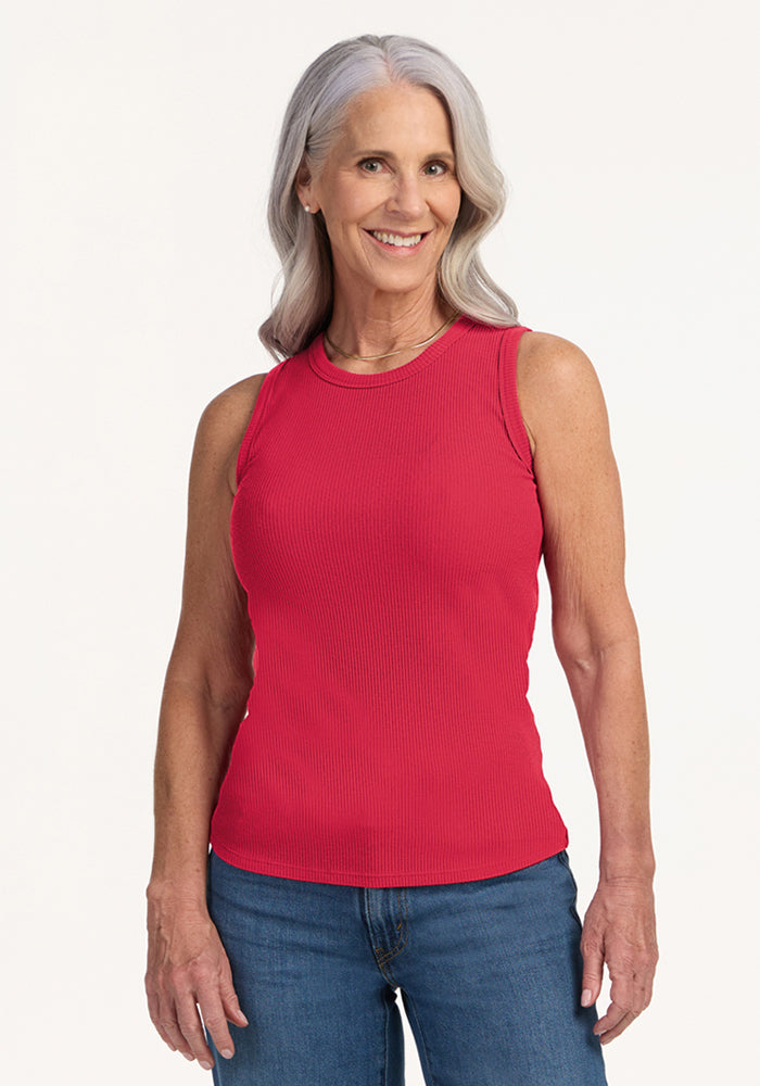 Smiling older woman in the Woolx Raegan Ribbed Tank Top - Berry Ice Pop and blue jeans, against a plain background. | Tam is 5’8.5”, wearing a size S
