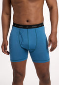 A person models the Woolx Reaction Boxer Briefs in Coastal Mini Stripe, featuring a black "woolx" waistband. The cropped image (shoulders to mid-thighs) against a white background emphasizes the fit of these performance underwear. | Trell is 6’2”, wearing a size M