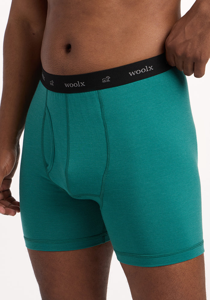 A person wears Woolx Reaction Boxer Briefs in Woodland Mini Stripe, featuring a black waistband with "woolx" in white. The image is cropped to show only the lower torso and upper thighs, highlighting this comfortable underwear.