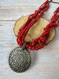 Red Beaded Torsade Necklace with Bronze Tone Filigree Pendant
