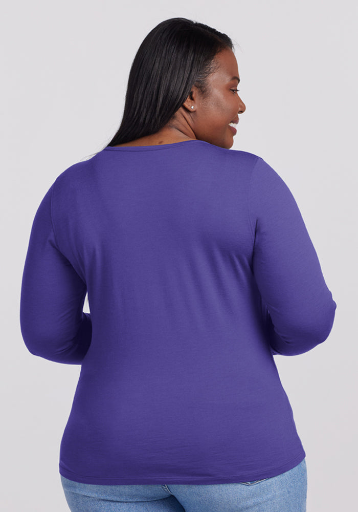 Woman with long dark hair in a Woolx Remi Long Sleeve T-Shirt - Berry Indigo and blue jeans, facing away.