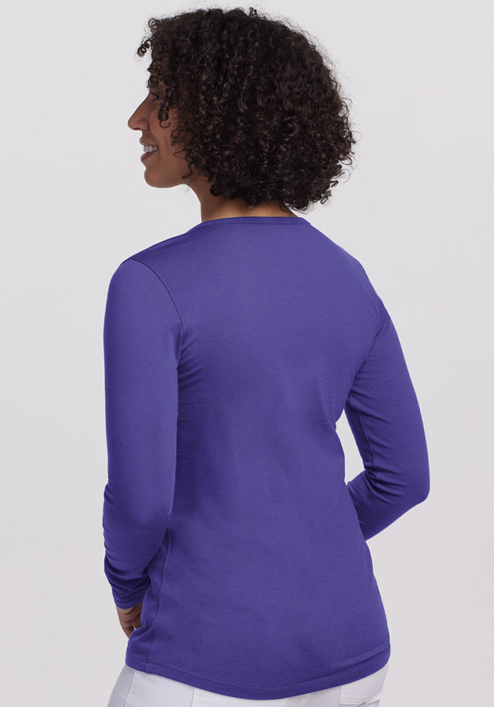 Person with curly hair wearing the Woolx Remi Long Sleeve T-Shirt in Berry Indigo, shown from the back.