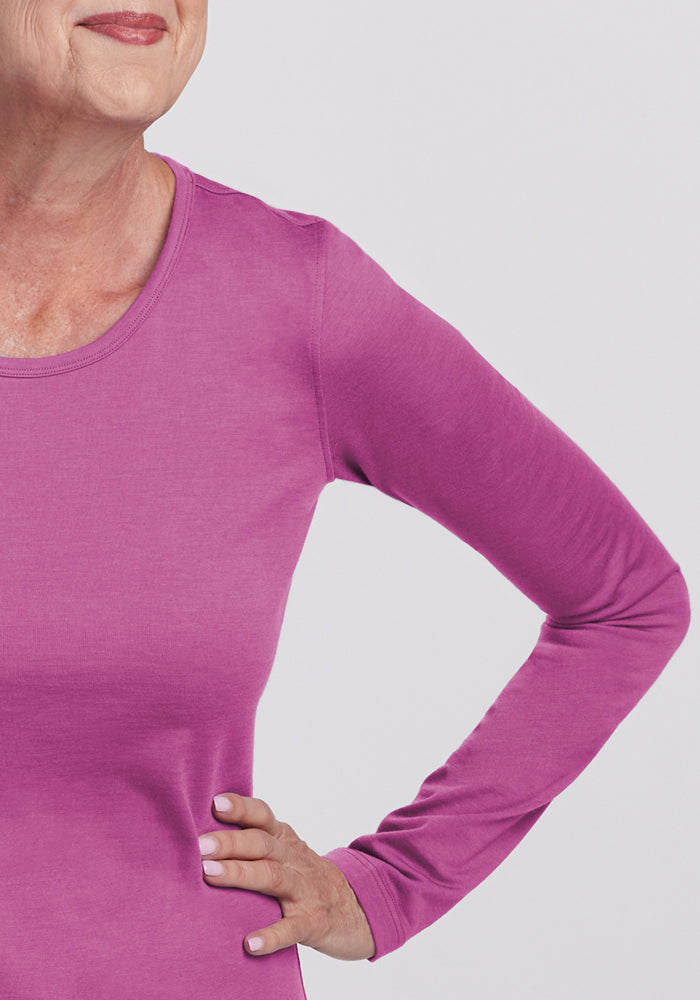 Smiling older woman in Woolx Remi Long Sleeve T-Shirt, Purple Wine, shown from nose to waist, hand on hip.