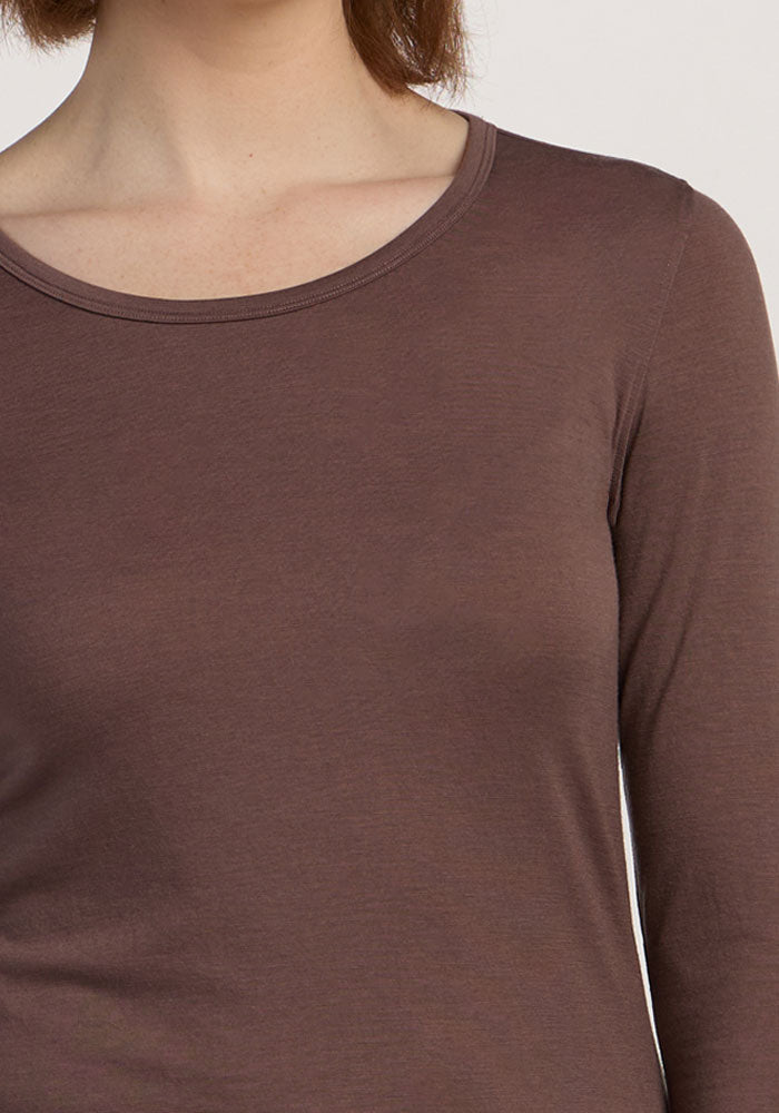 Someone wearing the Woolx Remi Long Sleeve T-Shirt in Peppercorn; only their upper torso and neck are visible.