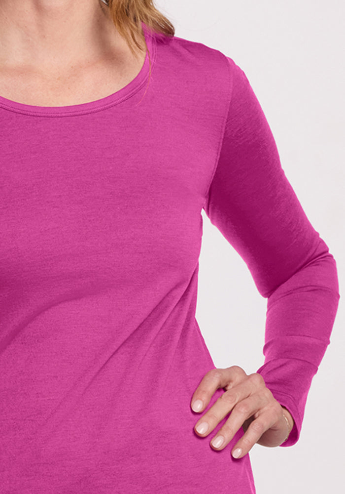 A woman models the Woolx Remi Long Sleeve T-Shirt in Summer Sorbet, shown neck to waist with hand on hip.
