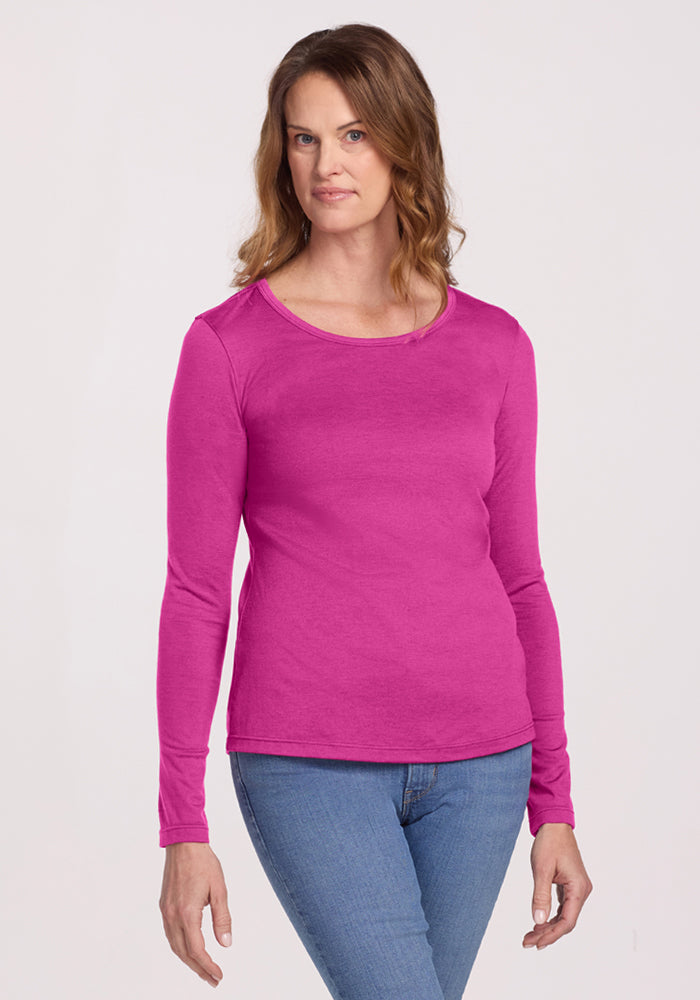 Woman in a Woolx Remi Long Sleeve T-Shirt in Summer Sorbet and blue jeans stands against a plain light background. | Toni is 5’11”, wearing a size S