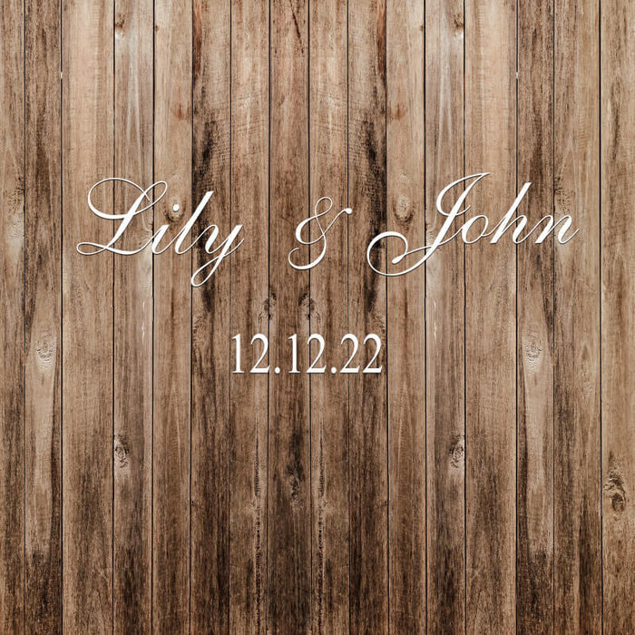 Close-up of rustic wood plank wedding backdrop with Lily and John names and date