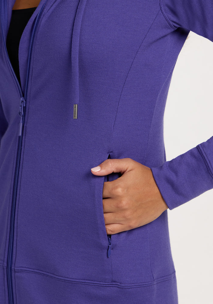 Hand with light pink nails in the pocket of a Woolx Ryann Hoodie - Berry Indigo, shown from the side.