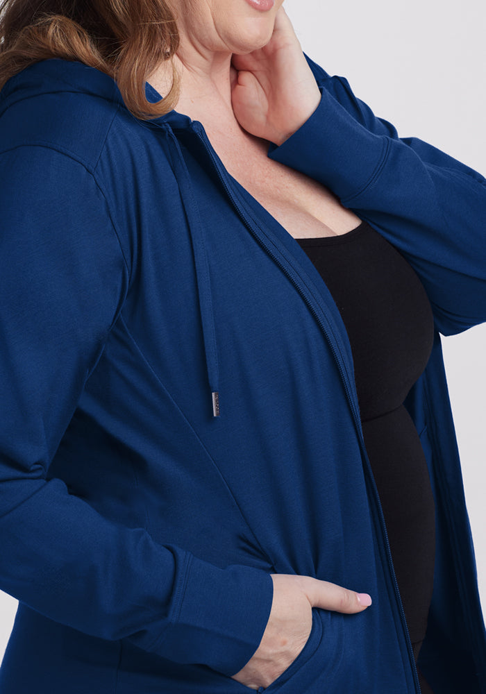 Woman wearing the Woolx Ryann Hoodie in Estate Blue, one hand in her pocket, the other near her neck.