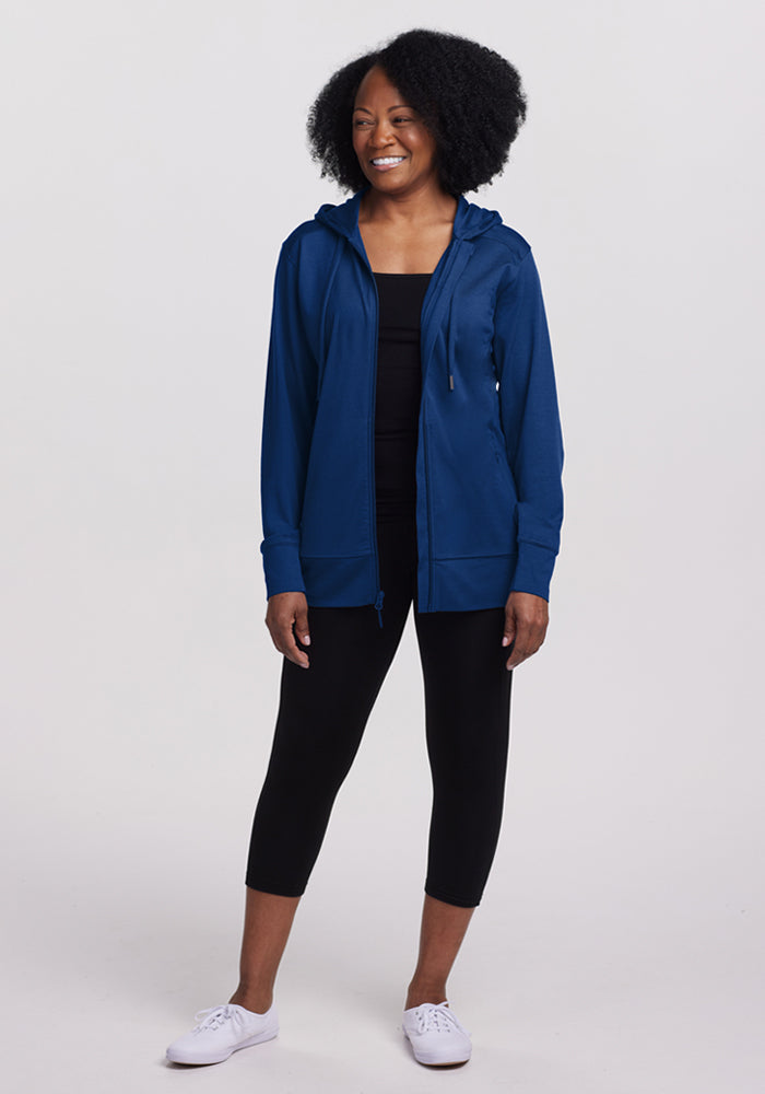 Woman in a Woolx Ryann Hoodie • Final Sale - Estate Blue, black leggings, and white sneakers stands against a light background.