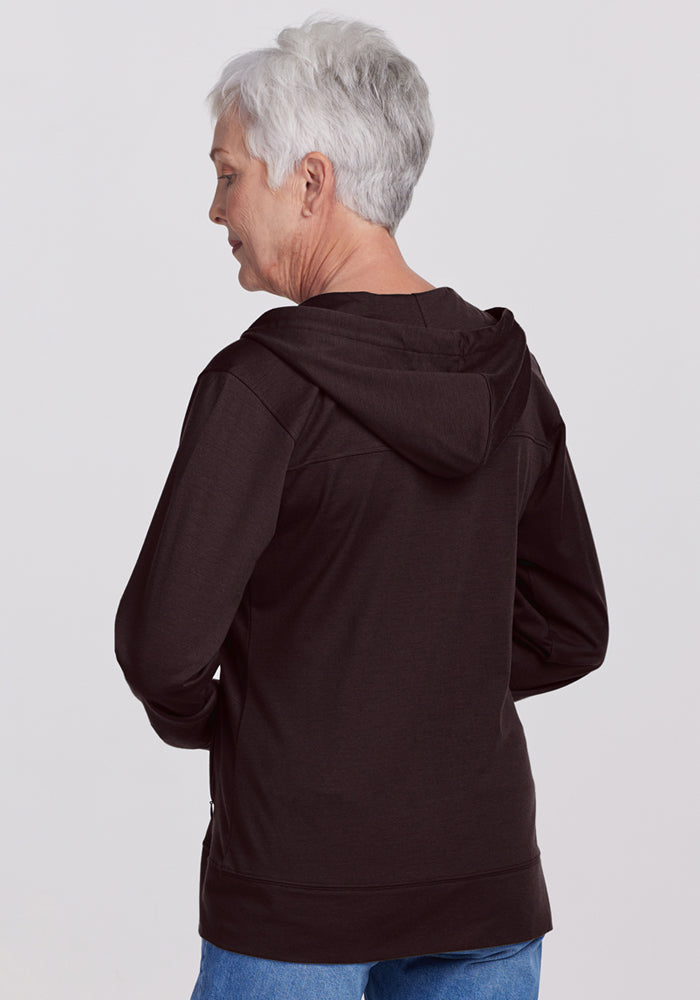 Older woman with short gray hair in a Woolx Ryann Hoodie • Final Sale - French Roast and blue jeans, seen from back.