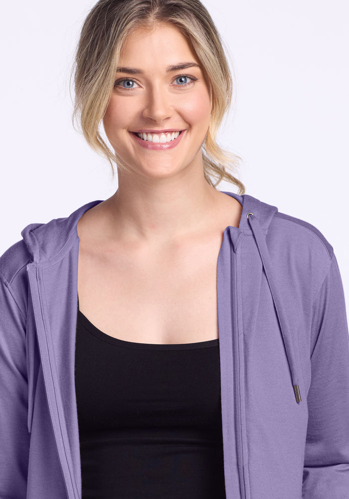Blonde woman in the Woolx Ryann Hoodie • Final Sale - Montana Grape, layering over black top against light background.