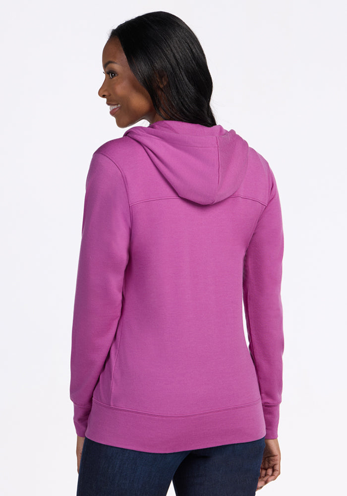 Woman facing away in the Woolx Ryann Hoodie in Purple Wine—your travel essential—paired with dark jeans.