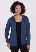 A woman wearing the Woolx Ryann Hoodie in Starry Night—a blue, moisture-wicking merino wool essential for travel.
